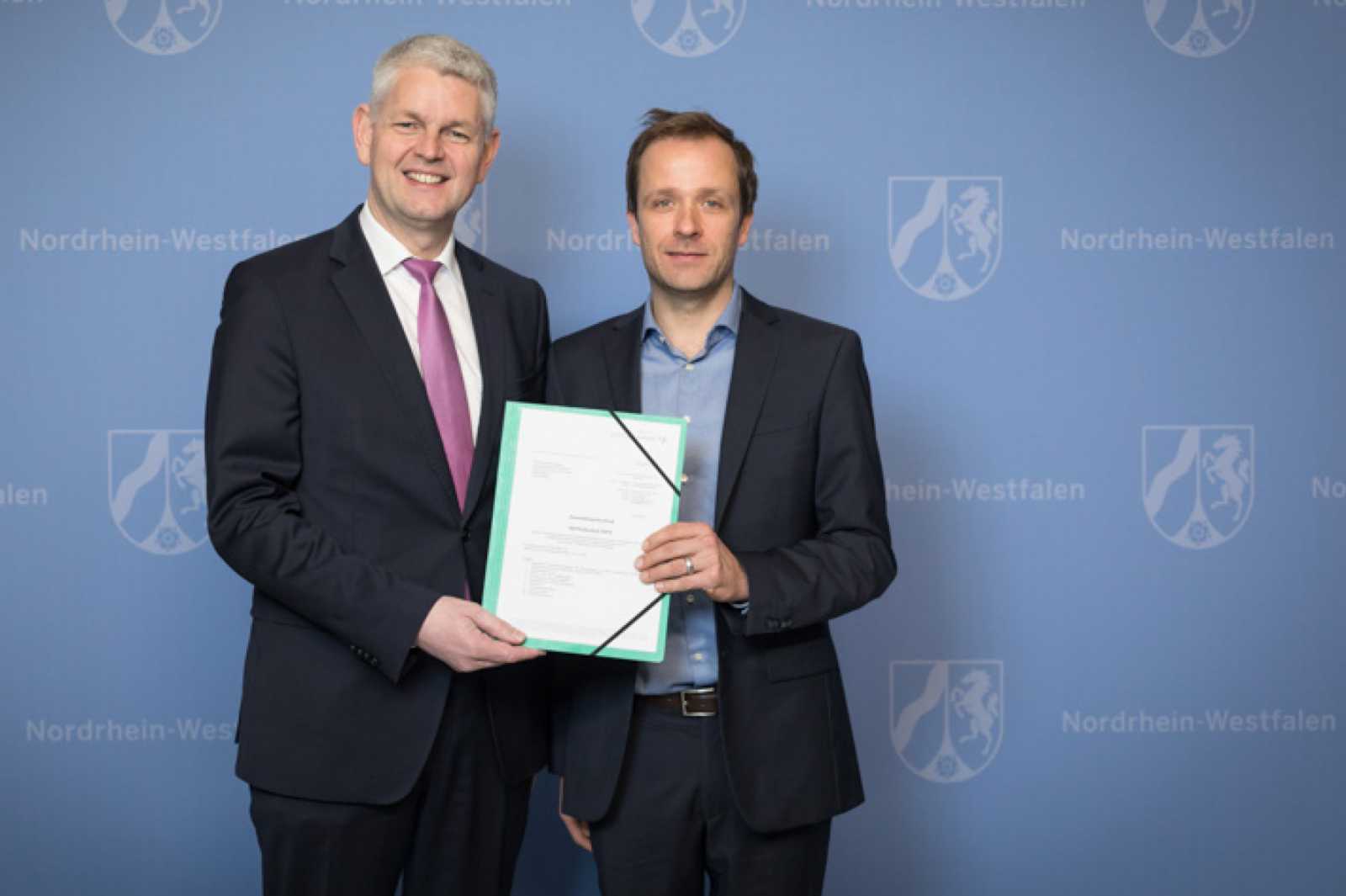 Staatssekretär Christoph Dammermann (l.) übergab den Förderbescheid an Prof. Dr. Sebastian Schinzel von der FH Münster. (Foto: Ralph Sondermann)