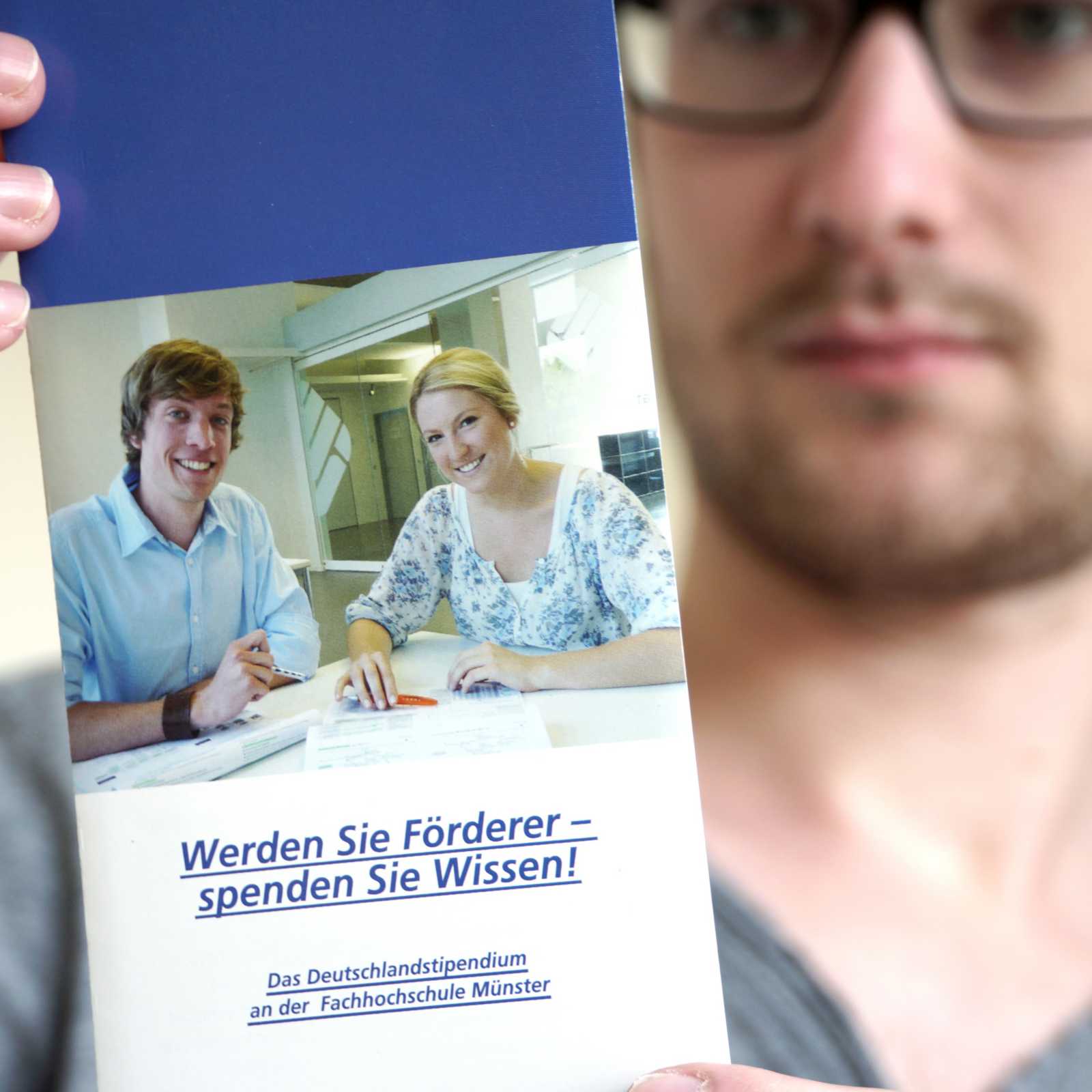 Ein Studierender mit dem Flyer zum Deutschlandstipendium an der FH Münser. (Foto: FH Münster/ Online-Redaktion)