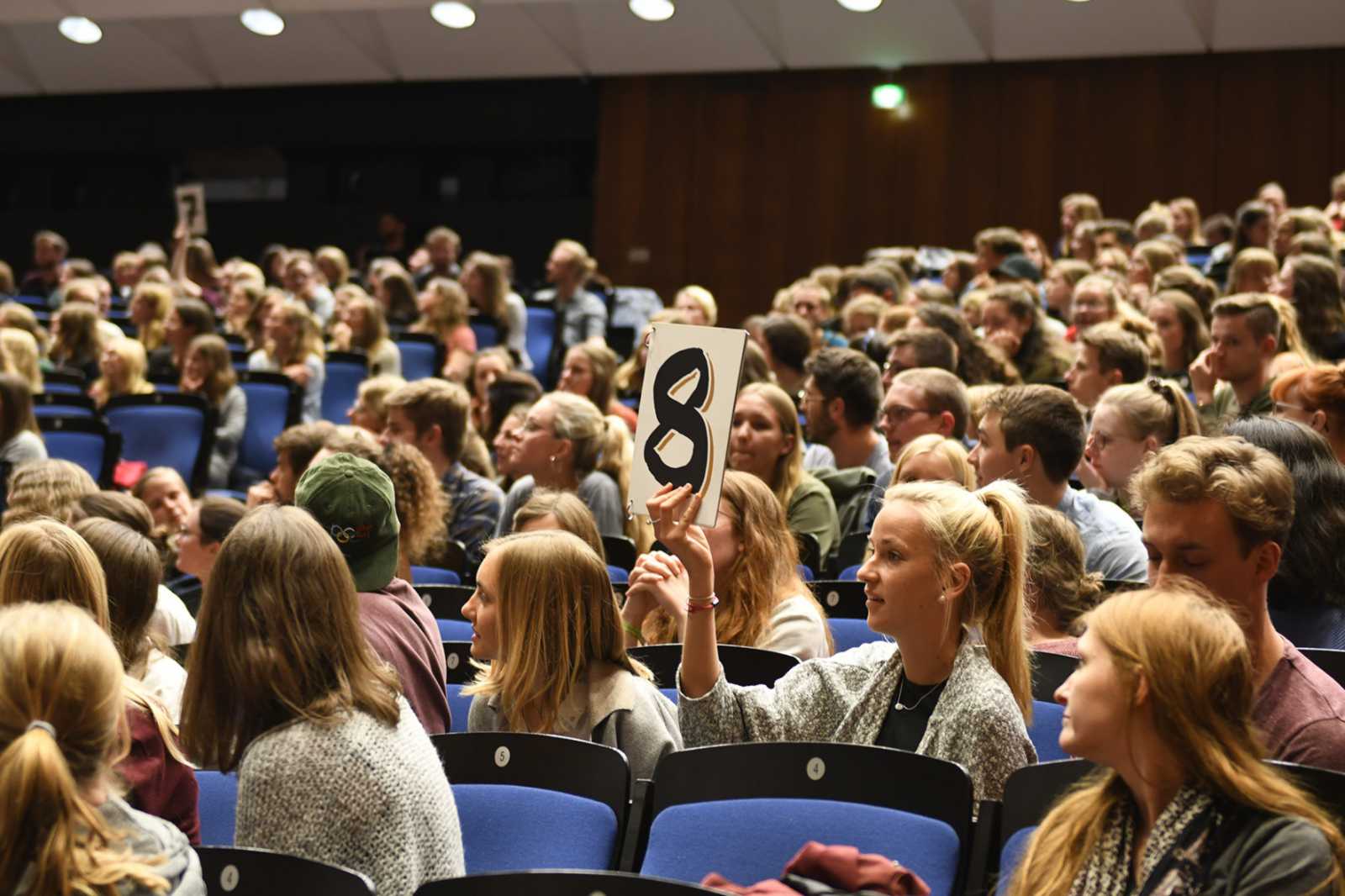 Mit mehreren Punktekarten, die zuvor im Publikum verteilt wurden, stimmen die Zuhörer für ihre Favoriten ab. (Foto: FH Münster/Pressestelle)