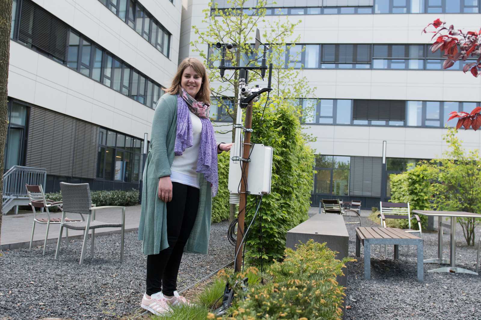 Birgitta Hörnschemeyer neben der Klimastationen am Fachhochschulzentrum, die ihre Simulationen mit Messdaten versorgen. (Foto: FH Münster/Theresa Gerks)