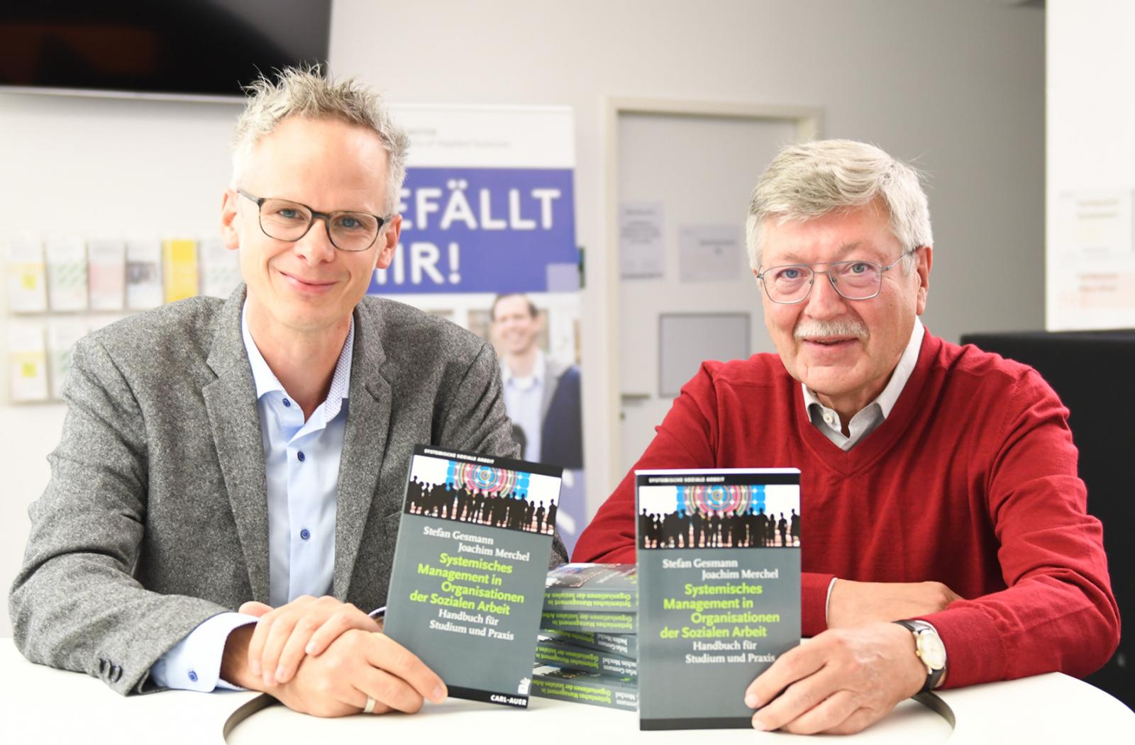 zusammen ein Handbuch über Systemisches Management in Organisationen der Sozialen Arbeit geschrieben: Prof. Dr. Stefan Gesmann (l.) und Prof. Dr. Joachim Merchel (r.). (Foto: FH Münster/Stefanie Gosejohann)