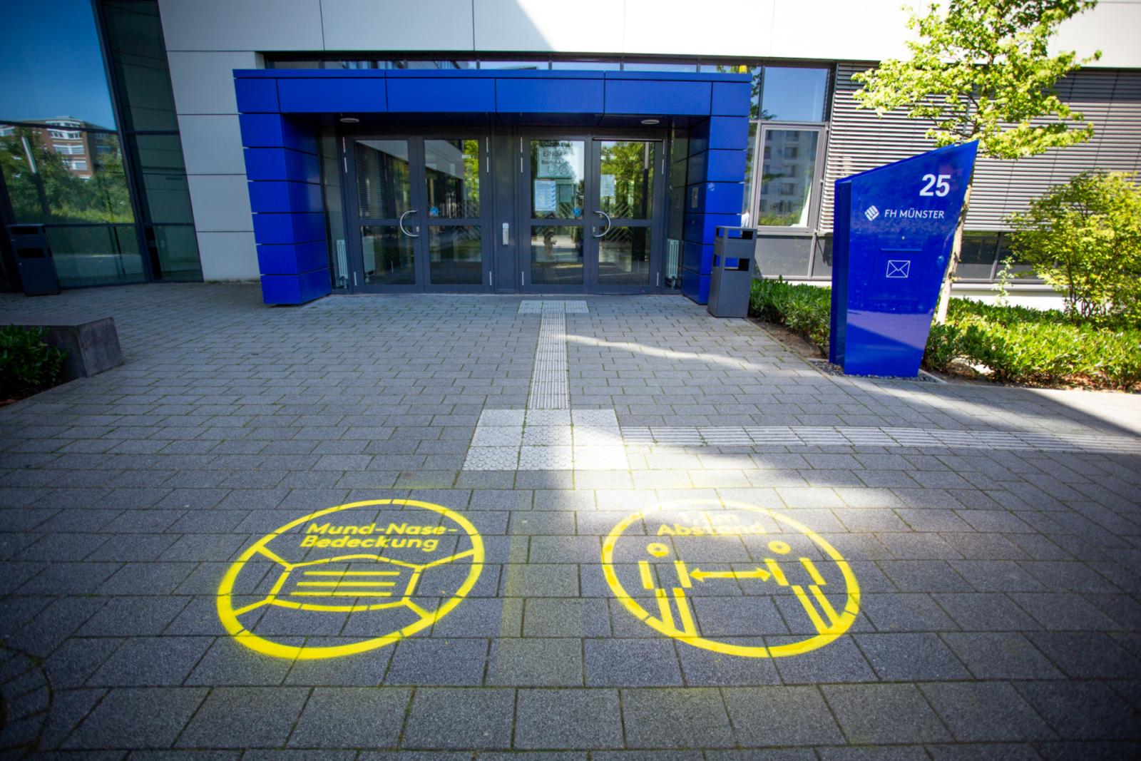 Graffiti für mehr Sicherheit: Vor den Gebäuden unserer Hochschule weisen farblich auffällige Markierungen auf die Abstands- und Hygieneregelungen während der Klausurphase hin. (Foto: FH Münster/Moritz Schäfer)