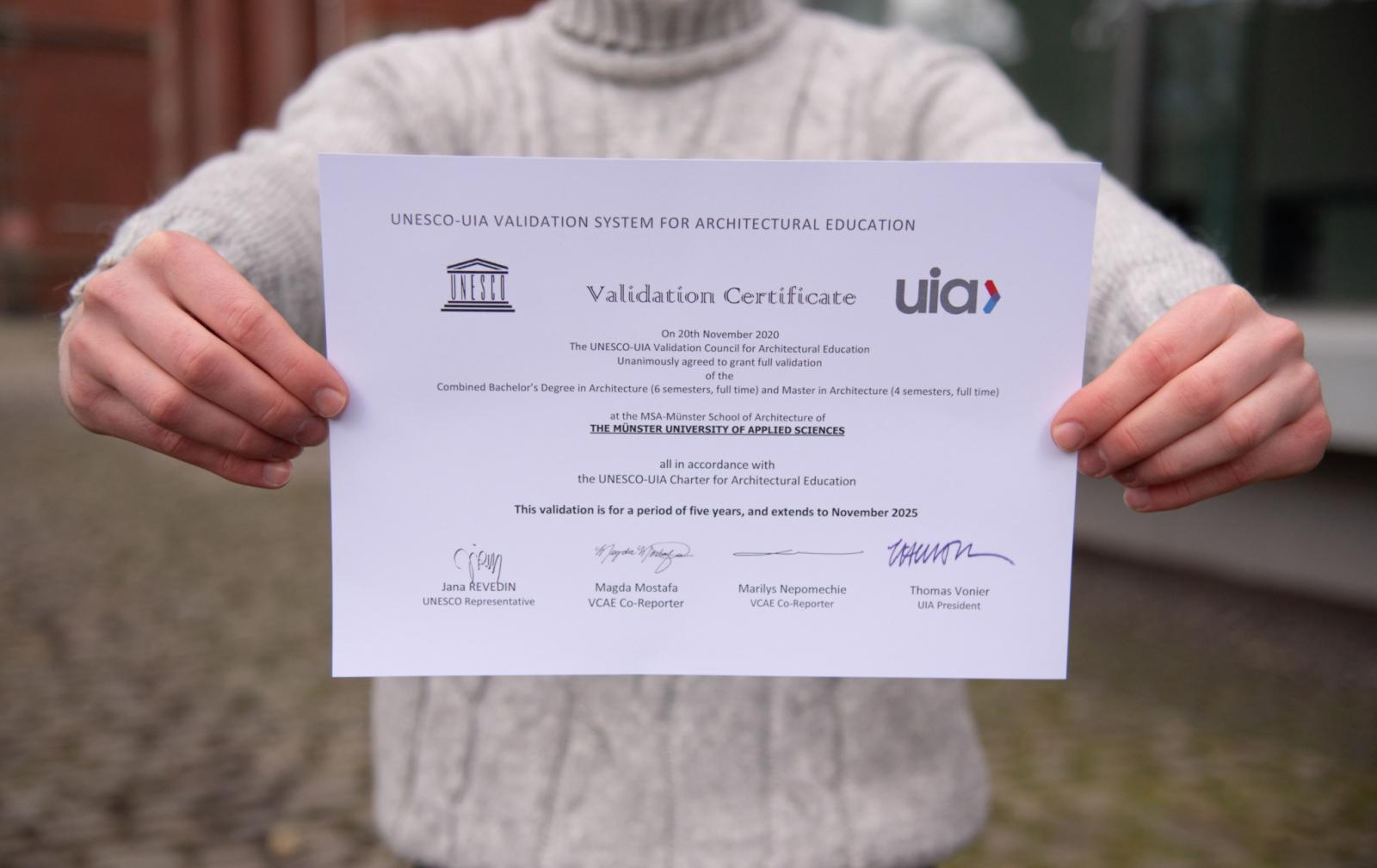 Till Bäumer-Kern präsentiert das UIA/UNESCO Qualitätssiegel. (Foto: FH Münster/Katharina Kipp)