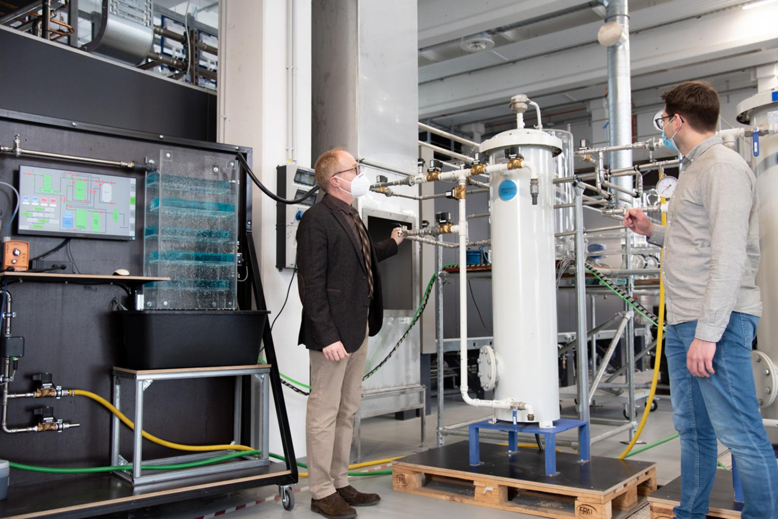 Prof. Dr. Helmut Grüning (l.) und Mark Scheffler stehen an der Anlage im Technikum für Hydraulik und Stadthydrologie. (Foto: FH Münster/Katharina Kipp) 