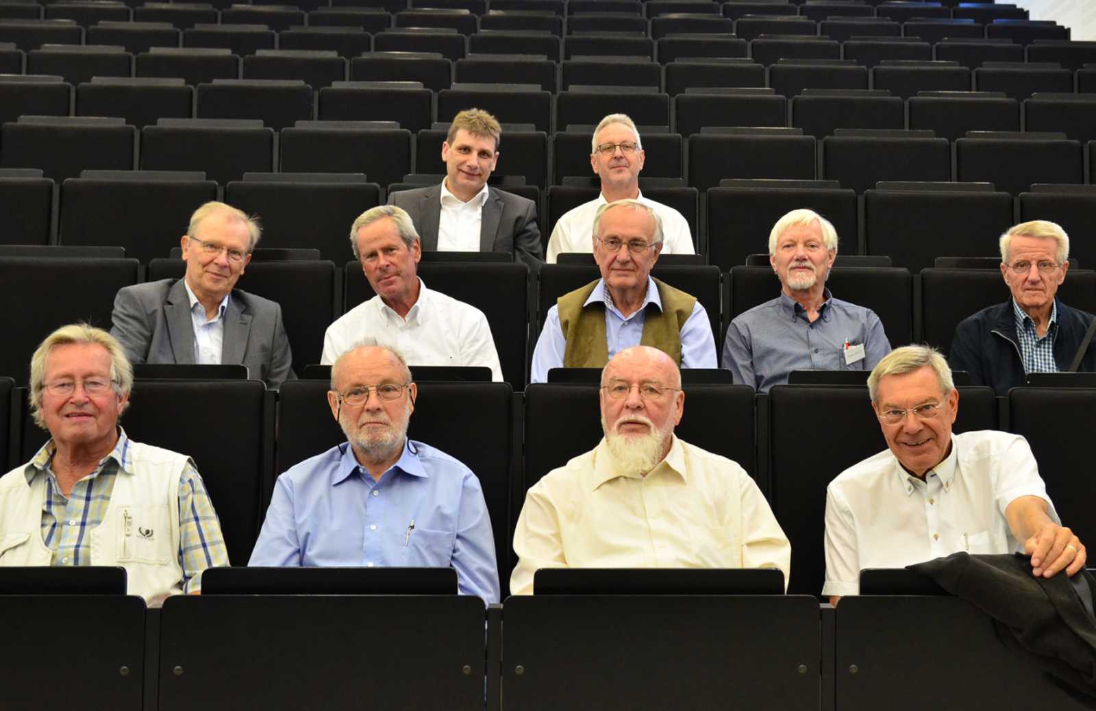 Prof. Dr. Eckhard Finke (oberste Reihe links) und Prof. Dr. Hans Effinger (oberste Reihe rechts) zeigten den Alumni den Campus in Steinfurt und auch den größten Hörsaal. (Foto: FH Münster/Pressestelle)