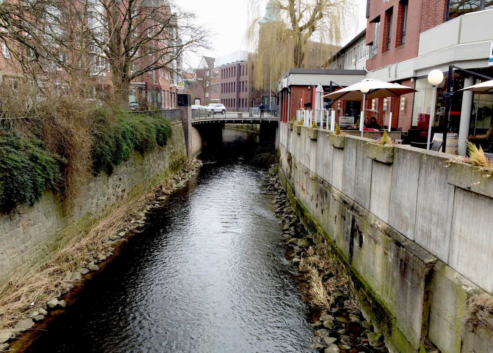 Die Münstersche Aa fließt durch ein eng betoniertes Flussbett in unmittelbarer Nähe von Wohnhäusern. (Foto: Helmut Grüning)