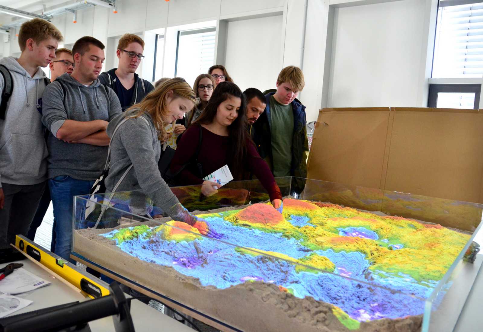 Einfach mal buddeln: Mit der Augmented-Reality-Sandbox im Technikum für Hydraulik und Stadthydrologie haben die Schülerinnen und Schüler den Gang des Regens an verschiedenen Landschaften beobachten können. (Foto: FH Münster/Pressestelle)