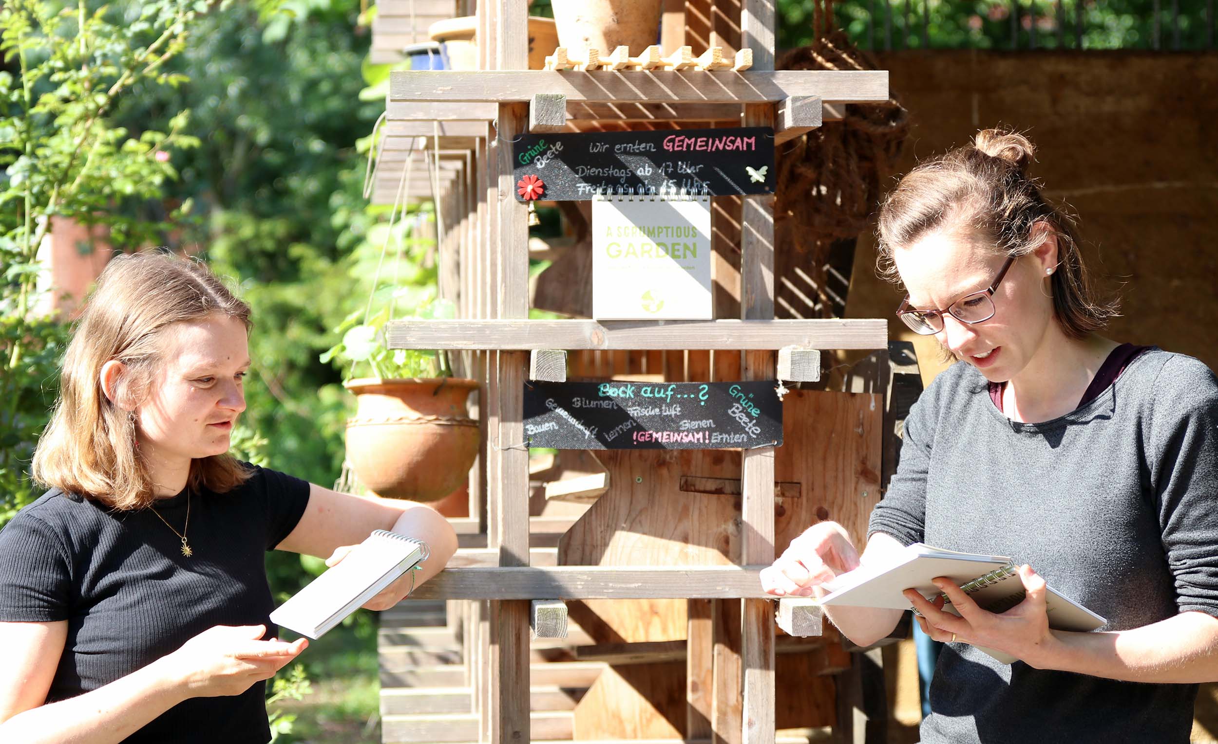 Yara Kobbe und Fara Steinmeier mit dem englischen Buch im Campusgarten Grüne Beete in Münster